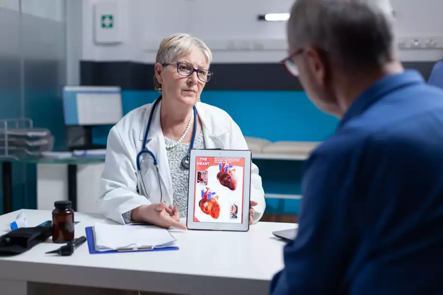 physician-explaining-cardiology-diagnosis-with-image-heart-organ-tablet-patient-general-practitioner-showing-illustration-cardiovascular-system-anatomical-structure-man 1